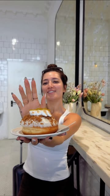 Guest holding a doughnut in the shop
