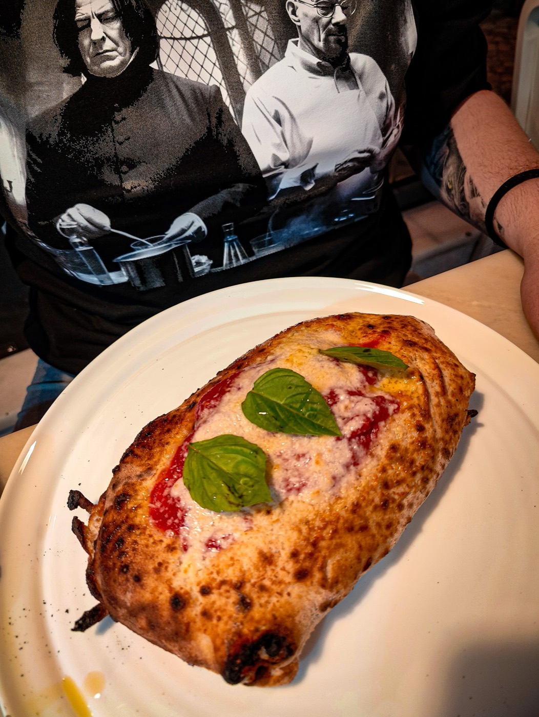 Baked calzone or saltimbocca topped with tomato sauce and basil leaf